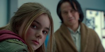 Movie still from “Jurassic World Dominion” (2022), directed by Colin Trevorrow – A young girl and an older man are looking at the camera; Close Up shot, Over the shoulder angle