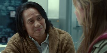 Movie still from “Jurassic World Dominion” (2022), directed by Colin Trevorrow – A man with long black hair wearing a brown sweater; Close Up shot, Over the shoulder angle