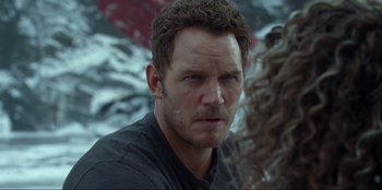 Movie still from “Jurassic World Dominion” (2022), directed by Colin Trevorrow – A person wearing a black shirt; Close Up shot, Over the shoulder angle