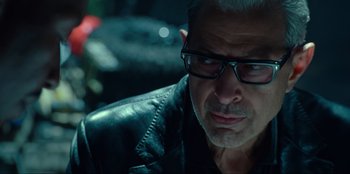 Movie still from “Jurassic World Dominion” (2022), directed by Colin Trevorrow – A person wearing glasses and a leather jacket; Close Up shot, Over the shoulder angle