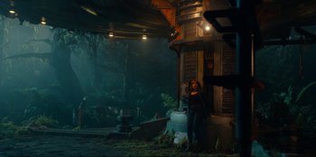 Movie still from “Jurassic World Dominion” (2022), directed by Colin Trevorrow – A woman standing in front of a building in the dark; Extreme Wide shot, Low angle