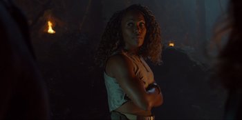 Movie still from “Jurassic World Dominion” (2022), directed by Colin Trevorrow – A woman standing with her arms crossed in the dark; Close Up shot, Over the shoulder angle