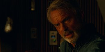 Movie still from “Jurassic World Dominion” (2022), directed by Colin Trevorrow – A person with a beard; Close Up shot, Over the shoulder angle