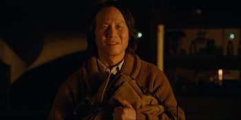 Movie still from “Jurassic World Dominion” (2022), directed by Colin Trevorrow – An older woman holding a purse in a dark room; Close Up shot, Low angle