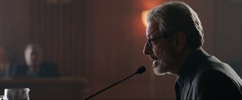 Movie still from “Jurassic World: Fallen Kingdom” (2018), directed by J.A. Bayona – An older man with glasses is speaking into a microphone; Close Up shot, Low angle
