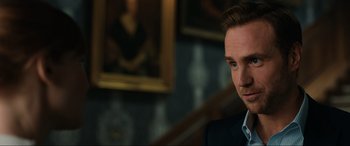 Movie still from “Jurassic World: Fallen Kingdom” (2018), directed by J.A. Bayona – A person wearing a suit and tie; Close Up shot, Over the shoulder angle