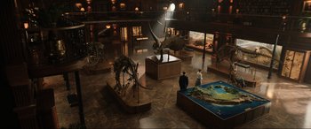 Movie still from “Jurassic World: Fallen Kingdom” (2018), directed by J.A. Bayona – Two people are looking at a display in a museum; Extreme Wide shot, High angle