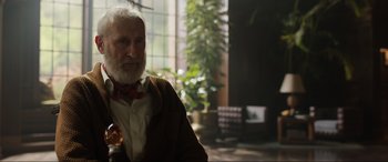 Movie still from “Jurassic World: Fallen Kingdom” (2018), directed by J.A. Bayona – An older man sitting in front of a window; Close Up shot, Over the shoulder angle