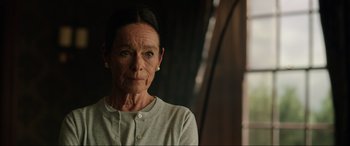 Movie still from “Jurassic World: Fallen Kingdom” (2018), directed by J.A. Bayona – An older woman is looking at the camera; Close Up shot, Over the shoulder angle