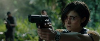 Movie still from “Jurassic World: Fallen Kingdom” (2018), directed by J.A. Bayona – A woman is holding a gun in the woods; Close Up shot, Over the shoulder angle