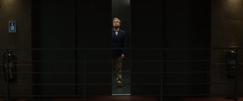 Movie still from “Jurassic World: Fallen Kingdom” (2018), directed by J.A. Bayona – A man standing in an elevator looking up at the ceiling; Wide shot, Low angle