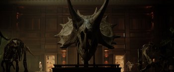 Movie still from “Jurassic World: Fallen Kingdom” (2018), directed by J.A. Bayona – A large dinosaur head statue in a room with lights; Close Up shot, Low angle