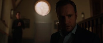 Movie still from “Jurassic World: Fallen Kingdom” (2018), directed by J.A. Bayona – A person wearing a suit in a room; Close Up shot, Over the shoulder angle
