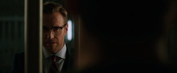 Movie still from “Jurassic World: Fallen Kingdom” (2018), directed by J.A. Bayona – A person wearing a suit and tie; Close Up shot, Over the shoulder angle