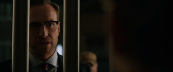 Movie still from “Jurassic World: Fallen Kingdom” (2018), directed by J.A. Bayona – A person wearing a suit and glasses; Close Up shot, Low angle