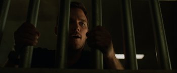 Movie still from “Jurassic World: Fallen Kingdom” (2018), directed by J.A. Bayona – A person behind a metal fence; Close Up shot, Low angle