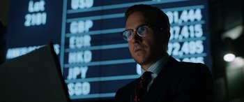 Movie still from “Jurassic World: Fallen Kingdom” (2018), directed by J.A. Bayona – A man in a suit and tie standing in front of a screen; Close Up shot, Over the shoulder angle