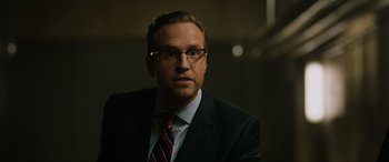 Movie still from “Jurassic World: Fallen Kingdom” (2018), directed by J.A. Bayona – A person wearing a suit and tie; Close Up shot, Over the shoulder angle