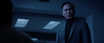 Movie still from “Jurassic World: Fallen Kingdom” (2018), directed by J.A. Bayona – A man wearing a suit and tie standing in a dark room; Close Up shot, Low angle