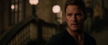 Movie still from “Jurassic World: Fallen Kingdom” (2018), directed by J.A. Bayona – A person wearing a black t - shirt; Close Up shot, Over the shoulder angle