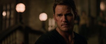 Movie still from “Jurassic World: Fallen Kingdom” (2018), directed by J.A. Bayona – A person wearing a black t - shirt; Close Up shot, Over the shoulder angle