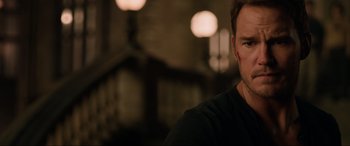 Movie still from “Jurassic World: Fallen Kingdom” (2018), directed by J.A. Bayona – A person wearing a black t - shirt; Close Up shot, Over the shoulder angle