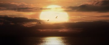 Movie still from “Jurassic World: Fallen Kingdom” (2018), directed by J.A. Bayona – Two birds flying over a body of water at sunset; Extreme Wide shot, Low angle