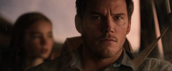 Movie still from “Jurassic World: Fallen Kingdom” (2018), directed by J.A. Bayona – A person looking at the camera; Close Up shot, Over the shoulder angle