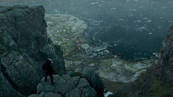 Movie still from “Justice League” (2017), directed by Zack Snyder – A man standing on a mountain looking down at a lighthouse; Extreme Wide shot, High angle