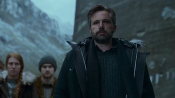 Movie still from “Justice League” (2017), directed by Zack Snyder – A man standing next to another man wearing a jacket; Medium shot, Low angle