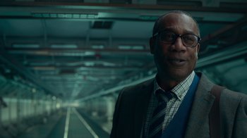 Movie still from “Justice League” (2017), directed by Zack Snyder – A man in a suit and tie standing in a train station; Close Up shot, Low angle