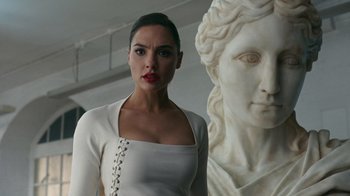 Movie still from “Justice League” (2017), directed by Zack Snyder – A woman standing next to a statue in a room; Close Up shot, Low angle