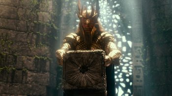 Movie still from “Justice League” (2017), directed by Zack Snyder – A man dressed as a king holding a box in a forest; Medium shot, Over the shoulder angle