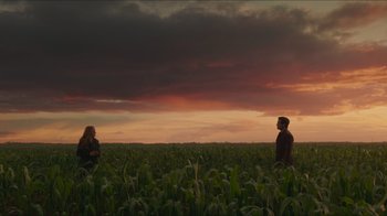 Movie still from “Justice League” (2017), directed by Zack Snyder – Two people are in a corn field under a cloudy sky; Extreme Wide shot, Low angle