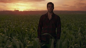 Movie still from “Justice League” (2017), directed by Zack Snyder – A man standing in the middle of a corn field at sunset; Medium shot, Low angle