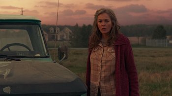 Movie still from “Justice League” (2017), directed by Zack Snyder – A woman standing in front of a truck in a field; Medium shot, Over the shoulder angle