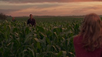 Movie still from “Justice League” (2017), directed by Zack Snyder – A man standing in the middle of a corn field at sunset; Extreme Wide shot, Over the shoulder angle