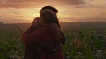 Movie still from “Justice League” (2017), directed by Zack Snyder – A woman is hugging a child in a field at sunset; Medium shot, Over the shoulder angle
