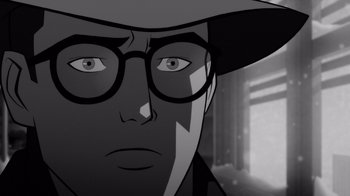 Movie still from “Justice League: Warworld” (2023), directed by Jeff Wamester – A man wearing glasses and a hat looking at the camera; Close Up shot, Over the shoulder angle