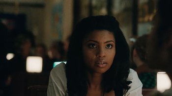 Movie still from “Atlanta” (2016), created by Donald Glover – A woman sitting in front of a group of people; Close Up shot, Over the shoulder angle