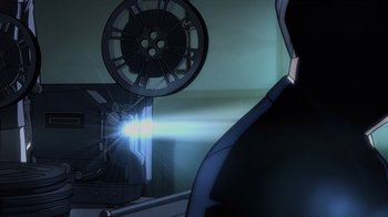 Movie still from “Justice Society: World War II” (2021), directed by Jeff Wamester – A man is watching a movie with a film projector; Medium shot, Low angle