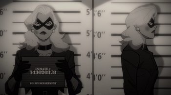 Movie still from “Justice Society: World War II” (2021), directed by Jeff Wamester – A woman in a black and white outfit holding a mugshot; Medium shot, Low angle