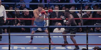 Movie still from “KSI: In Real Life” (2023), directed by Wes Pollitt – Two boxers in a boxing ring during a match; Medium shot, High angle