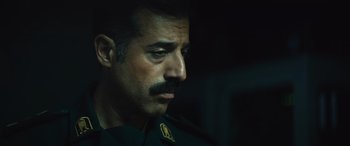 Movie still from “Kandahar” (2023), directed by Ric Roman Waugh – A person wearing a uniform; Close Up shot, Low angle