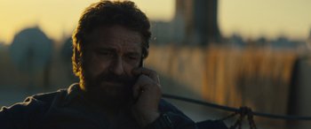 Movie still from “Kandahar” (2023), directed by Ric Roman Waugh – A person talking on a cell phone; Close Up shot, Over the shoulder angle