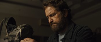 Movie still from “Kandahar” (2023), directed by Ric Roman Waugh – A person with a beard; Close Up shot, Low angle