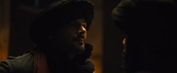 Movie still from “Kandahar” (2023), directed by Ric Roman Waugh – A person wearing a hooded jacket; Close Up shot, Over the shoulder angle