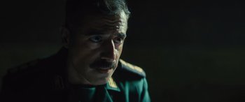 Movie still from “Kandahar” (2023), directed by Ric Roman Waugh – A person wearing a military uniform; Close Up shot, Over the shoulder angle