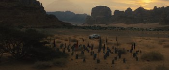 Movie still from “Kandahar” (2023), directed by Ric Roman Waugh – An suv is parked in the middle of the desert; Extreme Wide shot, High angle
