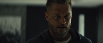 Movie still from “Kandahar” (2023), directed by Ric Roman Waugh – A person with a beard looking at the camera; Close Up shot, Over the shoulder angle